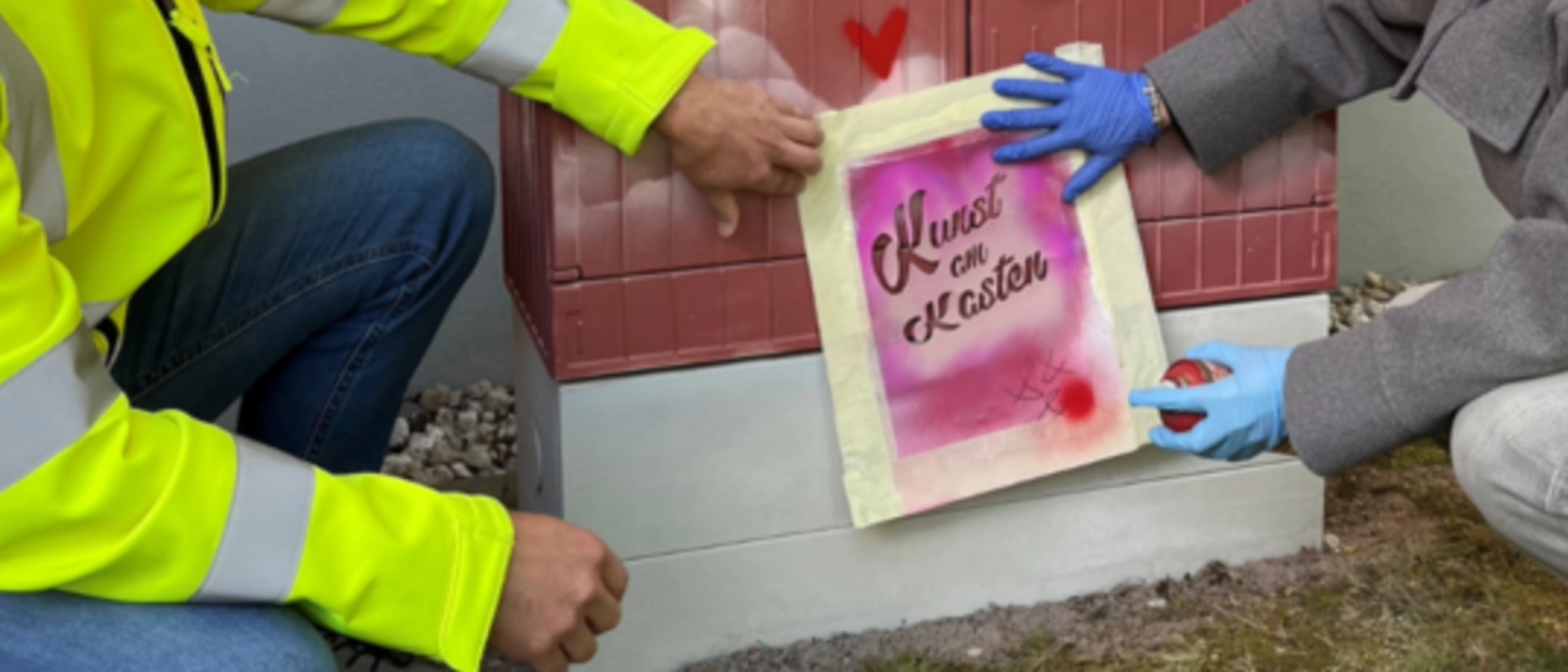 Zwei Personen an einem Stromkasten im Zuge des "Kunst am Kasten"-Projektes