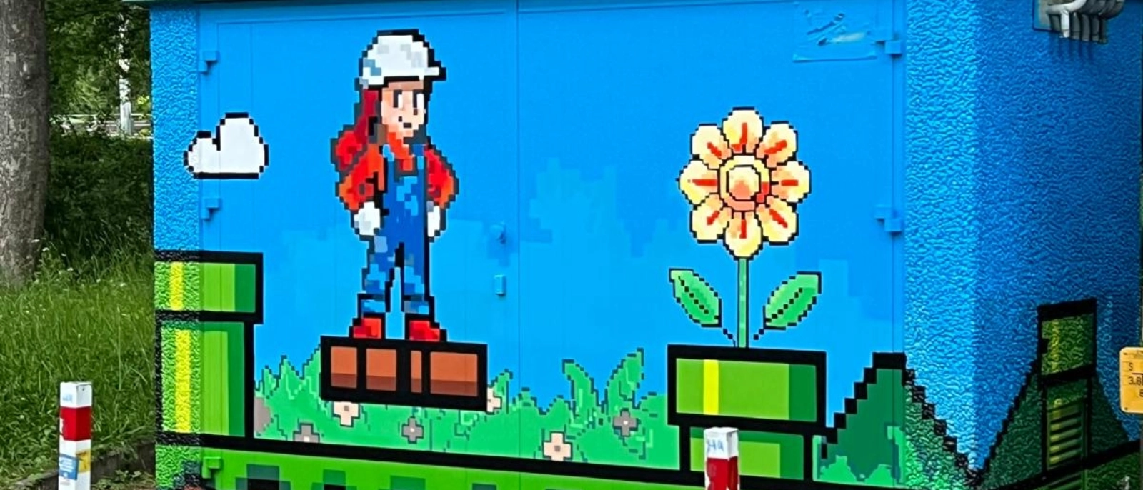 Auf den Anlagen am Alexander-Puschkin-Platz finden sich Pilze, Blumen und grüne Rohre und auch ein paar niedliche Bauarbeiter(innen) in rot-blauen Latzhosen.